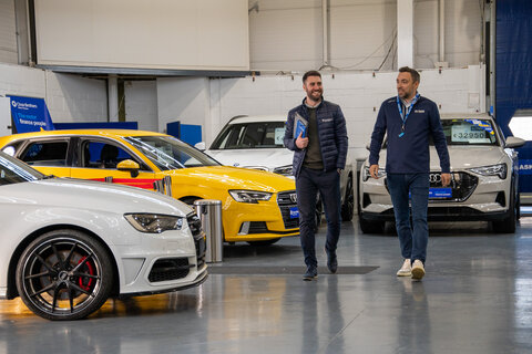 two men walking in a car dealership